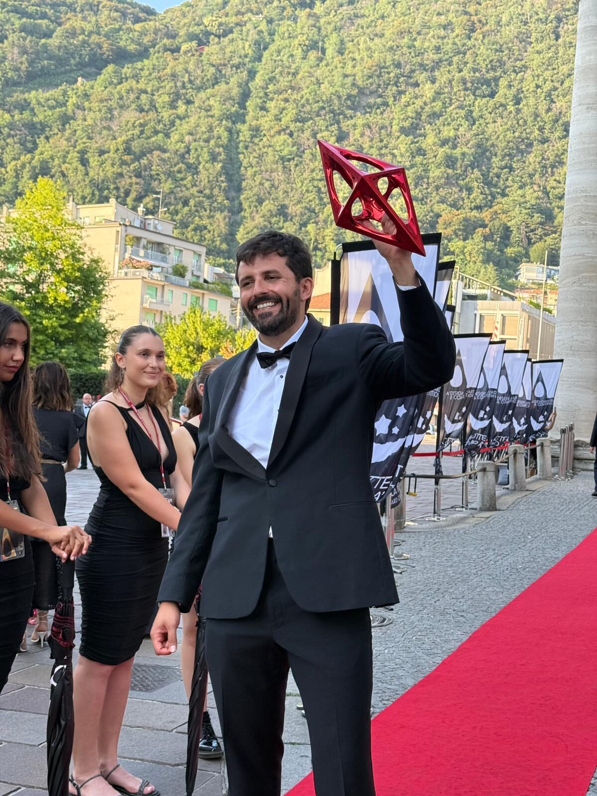 Eduardo Acero Rodriguez raising the A' Design Award trophy on stage.